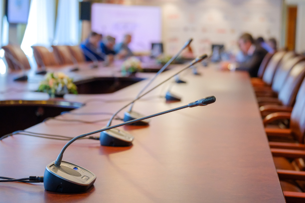 Conference room table with microphones for each participant